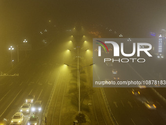 Vehicles are driving on the city's main road shrouded in thick smog and polluted air at night in Huai'an, China, on December 28, 2023. (