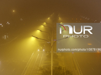 Vehicles are driving on the city's main road shrouded in thick smog and polluted air at night in Huai'an, China, on December 28, 2023. (