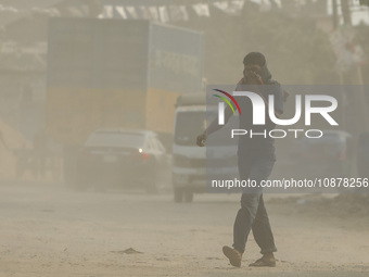 A man is walking on a dusty and heavily polluted road in Dhaka, Bangladesh, on December 2023. (