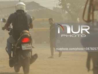 People are walking on a dusty and heavily polluted road in Dhaka, Bangladesh, on December 2023. (