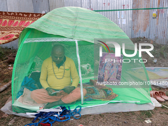 A devotee is resting inside a mosquito net at the Gangasagar Mela transit camp while on their way to the annual Hindu festival at Gangasagar...