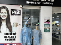 Mannequins are standing outside a shop that is selling face masks, hand sanitizer, and other personal protective equipment to help protect a...