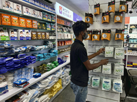 A man is purchasing N99 face masks at a shop that sells face masks, hand sanitizer, and other personal protective equipment to help protect...