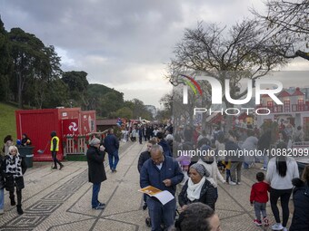 A group of people is walking through the aisles of a Christmas fair near Eduardo VII Park in Lisbon, Portugal, on December 30, 2023. (