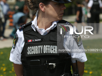 Security is standing guard during a Royal Fair celebrating the coronation of King Charles III at the Ontario Legislature Building (Queen's P...