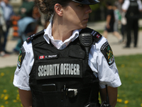 Security is standing guard during a Royal Fair celebrating the coronation of King Charles III at the Ontario Legislature Building (Queen's P...