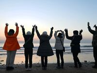 Tourists are welcoming the New Year sunrise at the Golden Beach in Qingdao, China, on January 1, 2024. (