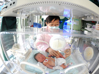 A medical worker is taking care of newborns at Dongfang Hospital in Lianyungang, China, on January 1, 2024. (