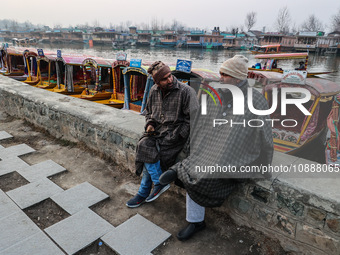 Shikara or boat owners are sitting on the banks of Dal Lake as they wait for tourists in Srinagar, Jammu and Kashmir, India, on January 3, 2...