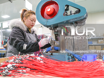 A worker is producing PTC heating block products at a micro factory in Xiashe village, Huzhou, China, on January 15, 2024. (