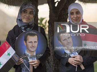 Supporters of Syria's President Bashar al-Assad are holding Syrian flags and portraits of Bashar al-Assad during the 2014 Syrian Presidentia...