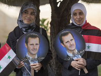 Supporters of Syria's President Bashar al-Assad are holding Syrian flags and portraits of Bashar al-Assad during the 2014 Syrian Presidentia...