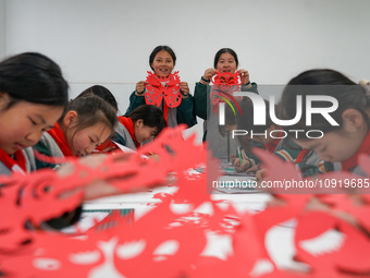 Children from a paper-cutting club are creating works themed on the Year of the Dragon to welcome the Spring Festival in Suqian, Jiangsu Pro...