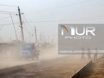 People are moving along a dusty, busy road in Dhaka, Bangladesh, on January 18, 2024. (