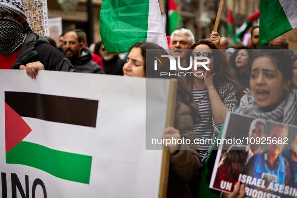 Protesters are holding Palestinian flags and shouting slogans in support of Palestine and against the Israeli government's actions in the Ga...