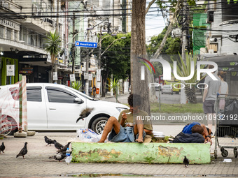 A homeless man is eating on the street in Niteroi, Brazil, on January 21, 2024. (