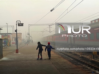 Children are playing on a railway platform while dense smog is visible in the background in Lucknow, Uttar Pradesh, India, on January 23, 20...