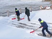 Sanitation workers are clearing snow at a beach in Yantai, China, on January 22, 2024. (