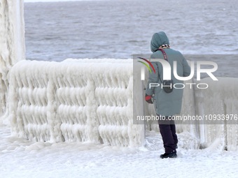 A tourist is viewing the frozen scene at the seaside in Yantai, China, on January 22, 2024. (