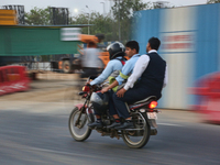 Boys are traveling on a motorbike in Greater Noida, Uttar Pradesh, India, on May 3, 2022. (