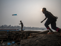 A child is flying a kite on the bank of the River Buriganga in Dhaka, Bangladesh, on January 25, 2024. (