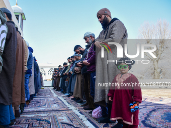 A Kashmiri girl is posing for a picture while people are praying at the Hazratbal shrine on the day of Mehraj ul Alam in Srinagar, Indian Ad...