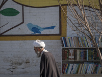 An elderly Iranian cleric is walking past an outdoor bookstore in the holy city of Qom, 145 km (90 miles) south of Tehran, on February 7, 20...