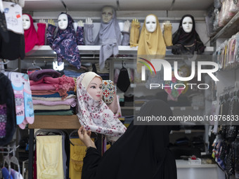 A veiled Iranian woman is looking at a headscarf while shopping at a shop in the holy city of Qom, 145 km (90 miles) south of Tehran, on Feb...