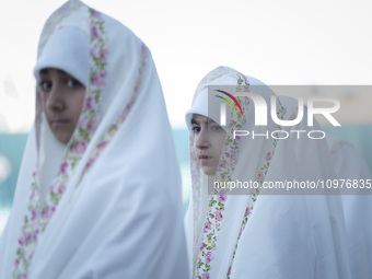 Veiled Iranian schoolgirls are looking on while participating in a ceremony at the holy mosque of Jamkaran on the outskirts of the holy city...