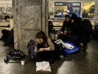 Schoolchildren are completing a school assignment in a metro station being used as a bomb shelter during a long air alert in Kyiv, Ukraine,...