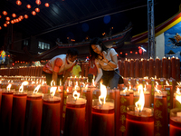 A woman is lighting candles and offering prayers for good fortune to mark the Lunar New Year of the Dragon at Dhanagun Temple in Bogor, West...