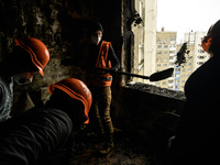 Local residents and volunteers are cleaning up debris in an apartment building that was heavily damaged during a massive Russian missile att...