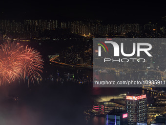 Fireworks are exploding over Victoria Harbour next to skyscrapers in Central in Hong Kong, on February 11, 2024. This is the first Lunar New...