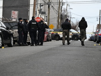 A vehicle is being struck by gunfire, and several shell casings are lying in the street on 12th Avenue in Paterson, New Jersey, United State...