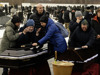 Relatives and friends are reacting during a funeral ceremony for a family and their three children who died in a fire following an attack by...