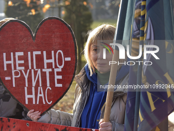 A woman is holding a heart-shaped red placard during a rally in Yevropeiska Square in Vinnytsia, Ukraine, on February 10, 2024, to remind pe...