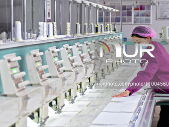 A worker is producing embroidery products at a workshop of a textile and embroidery company in Yantai, China, on February 18, 2024. (