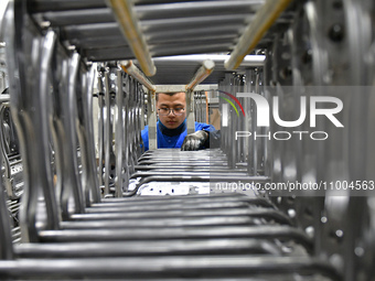 A worker is conducting a product quality inspection at a workshop of an auto parts company in Yantai, China, on February 18, 2024. (