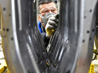 A worker is working on the production line at a workshop of an auto parts company in Yantai, China, on February 18, 2024. (