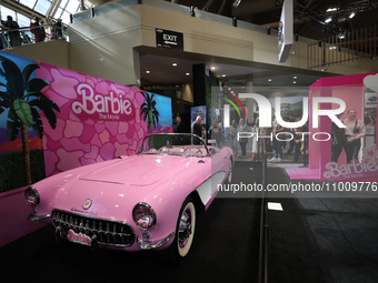 People are taking photos of a Barbie-themed convertible at the Canadian International Auto Show in Toronto, Canada, on February 19, 2024. (