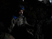 A serviceman from the 65th Separate Mechanized Brigade of the Land Forces of the Armed Forces of Ukraine is standing in the darkness of a tr...