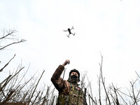 A serviceman from the 65th Separate Mechanized Brigade of the Land Forces of the Armed Forces of Ukraine is launching a drone into the sky n...