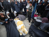 People are mourning over the bodies of relatives killed in an overnight Israeli bombardment at the Shuhada Al-Aqsa hospital in Deir Balah in...