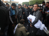 People are mourning over the bodies of relatives killed in an overnight Israeli bombardment at the Shuhada Al-Aqsa hospital in Deir Balah in...