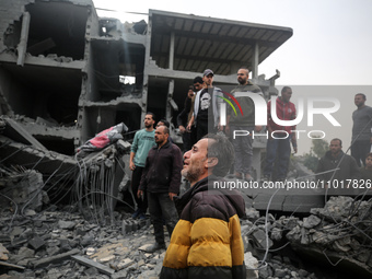 People are checking the destruction caused by overnight Israeli bombardment in Deir Balah in the central Gaza Strip on February 23, 2024, as...