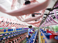 A female worker is merging silk at a production workshop of a silk company in Chongqing, China, on February 23, 2024. (
