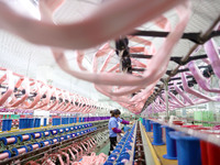 A female worker is merging silk at a production workshop of a silk company in Chongqing, China, on February 23, 2024. (