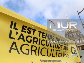 French farmers are hanging a banner with the inscription ''It's time to return agriculture to the farmers'' during a demonstration of the Co...