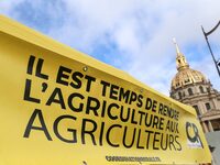 French farmers are hanging a banner with the inscription ''It's time to return agriculture to the farmers'' during a demonstration of the Co...