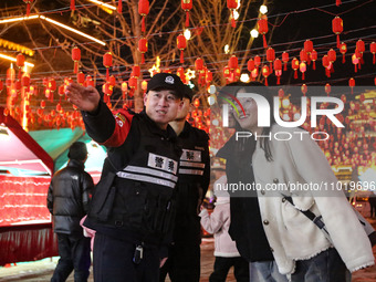 Police officers are giving directions to tourists at the Tanguo Ancient City scenic spot in Linyi, China, on February 23, 2024. (